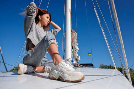 Beautiful young woman posing on yacht. Model is sailing on board.の写真素材