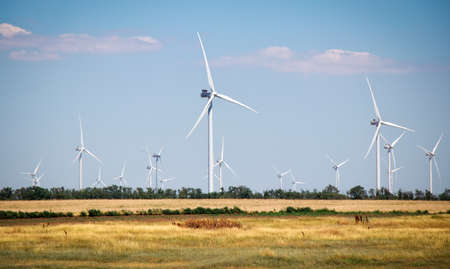 Wind turbines and agricultural field on a summer day. Energy production, clean and renewable energy.の写真素材
