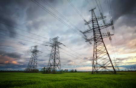 Silhouette High voltage electric towers at sunset time. High-voltage power lines. Electricity distribution stationの写真素材