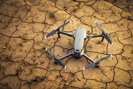 Close-up small drone on brown soil in the field. Flying in the countryside.の写真素材