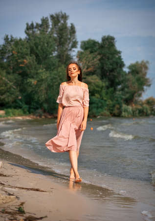 Young girl walking in water by the coastline.の写真素材