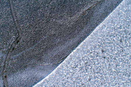 Frozen ice on the shore of the reservoir as a background, a bird's-eye view.の写真素材