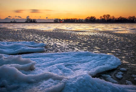 Sunrise and frozen river. Beautiful winter landscape with lake in morning time. Daybreakの写真素材
