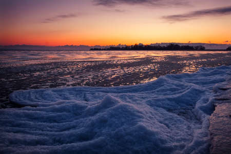 Natural Winter landscape on seashore during sunset. Ice and sunset sky.の写真素材