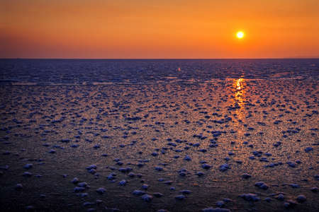 Natural Winter landscape on seashore during sunset. Ice and sunset sky.の写真素材