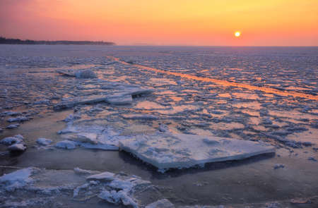 Sunrise and frozen sea. Beautiful winter landscape with lake in morning time.の写真素材