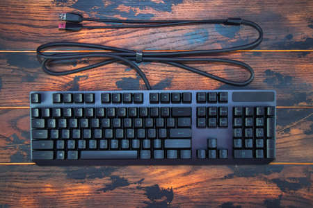 Modern gaming keyboard on a wooden background. View from above.の写真素材