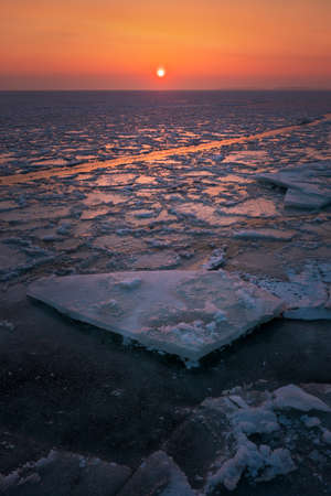 Sunrise and frozen sea. Beautiful winter landscape with lake in morning time.の写真素材