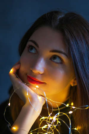 A girl with with a Christmas garland in her hands.の写真素材