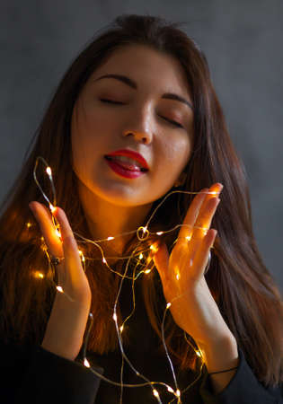 A girl with with a Christmas garland in her hands.の写真素材