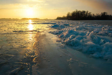 Sunrise and frozen sea. Beautiful winter landscape with lake in morning time.の写真素材