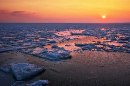 Sunrise and frozen sea. Beautiful winter landscape with lake in morning time.の写真素材