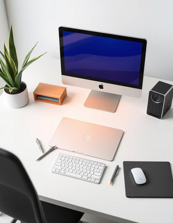 Workplace with computer, stationery and plant on table in office