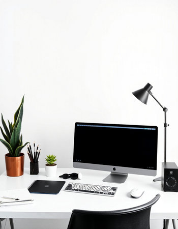 workplace with computer, lamp, tablet and stationery on table