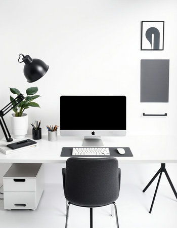 workplace with computer on white table, lamp and plant