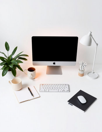 Modern workspace with computer, supplies and coffee cup on white background.