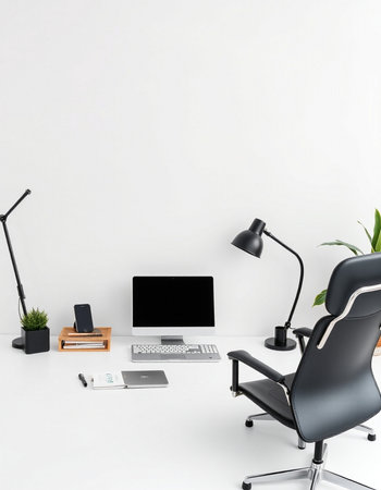 workplace with laptop, lamp and office supplies on white wall backgroundの写真素材