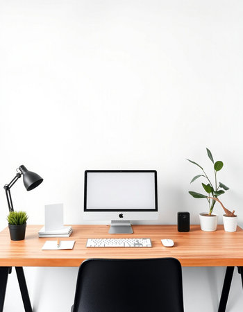 workplace with computer, lamp and plant on white wall background.