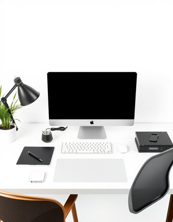 Modern workspace with blank computer screen, supplies and coffee cup.