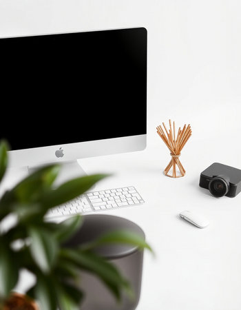 Workplace with computer, camera and plant on white background, top view