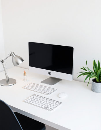 Minimal workspace with computer, keyboard, mouse, coffee cup and other itemsの写真素材