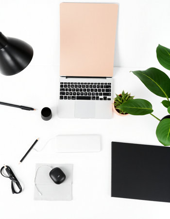Flat lay of modern workspace with laptop, stationery and copy space on white backgroundの写真素材