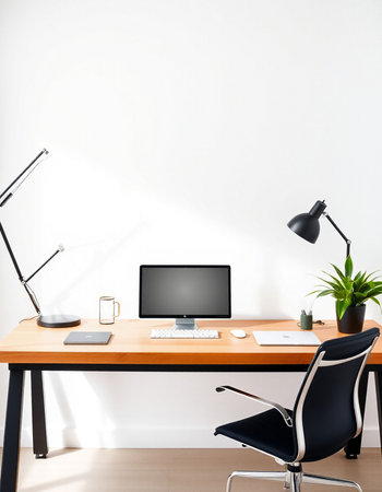 workplace with computer, lamp and plant on wooden desk in office
