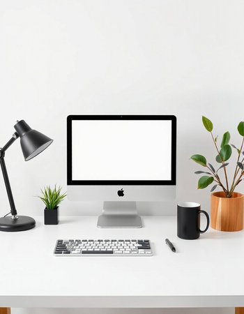 workplace with computer, keyboard, coffee cup, plant and lamp