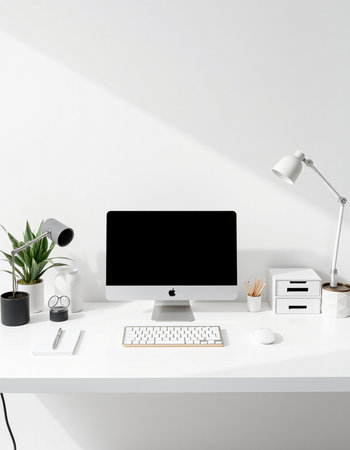 workplace with computer, lamp and stationery on white wall backgroundの写真素材