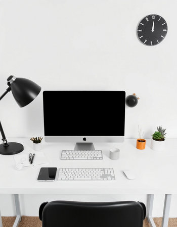 Workplace with computer, stationery and clock on white wall backgroundの写真素材