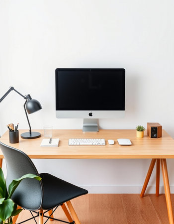 Office desk with computer, keyboard, mouse, keyboard, lamp and plantの写真素材