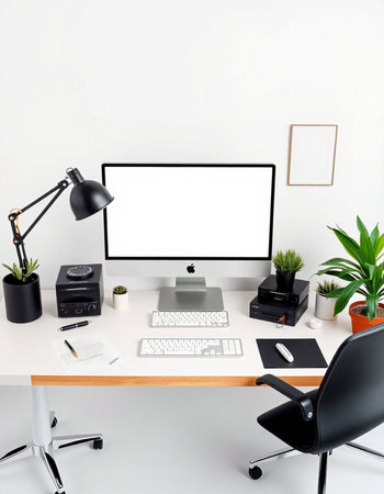 workplace with computer, keyboard, lamp, plant and office suppliesの写真素材