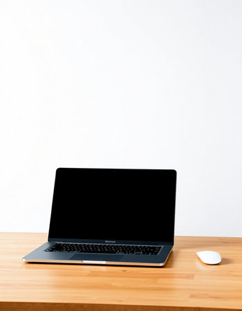 Laptop with blank screen on wooden table and white wall background.