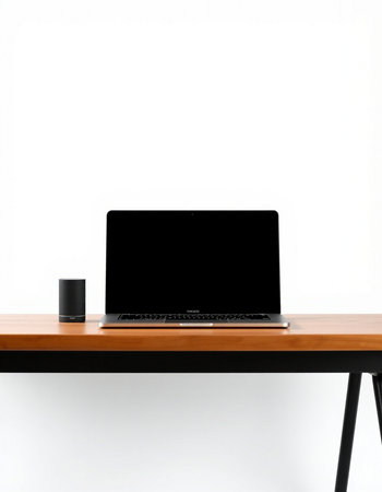 Laptop with blank screen on wooden table and white wall background.の写真素材