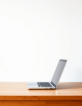 Laptop on wooden table and white wall background. Copy space.