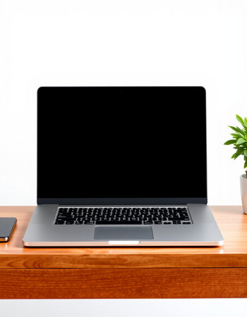 Laptop with blank screen on wooden table and white wall background.