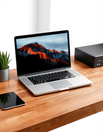 laptop on wooden desk with computer and smart speaker on white background