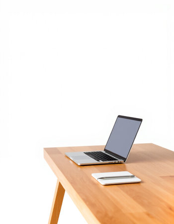 Laptop on a wooden table against a white background with copy space