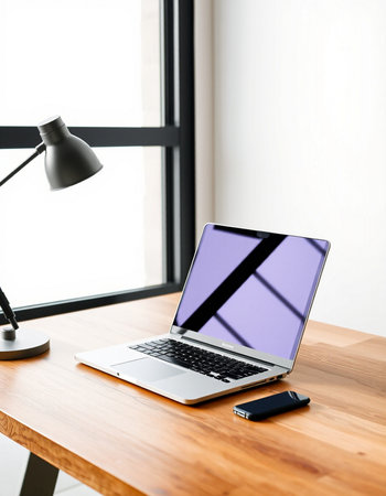 Laptop with blank screen on wooden table in office, stock photo