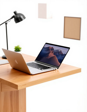 Laptop on a wooden table with a picture frame in the background