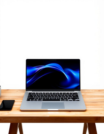 Laptop on a wooden table against a white wall with copy space