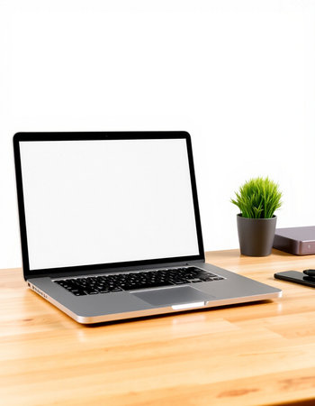 Laptop computer with blank screen on wooden table and white wall background