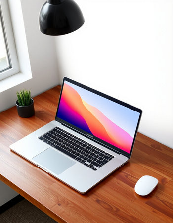 Laptop on a wooden desk in a room with a white wall