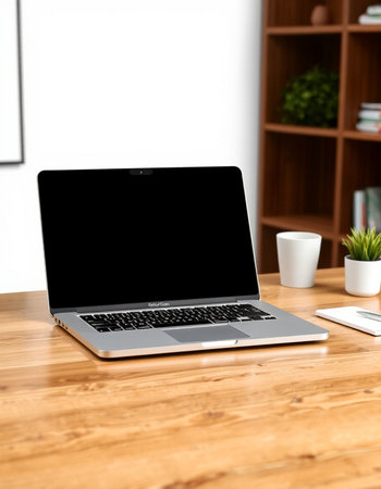 Laptop with blank screen on wooden table in office. Mock up