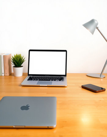 Laptop with blank screen on wooden desk and lamp on white wall backgroundの写真素材