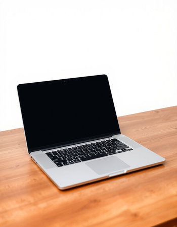 Laptop computer on wooden table with white wall background, stock photo