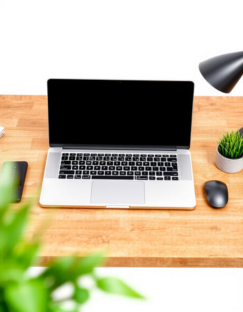 Modern workplace with laptop, smartphone, coffee cup and other items on wooden table