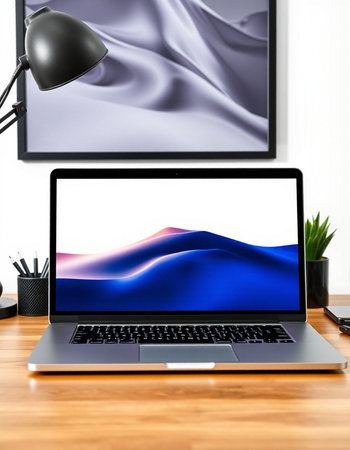 Laptop on wood table with black lamp and white fabric background.