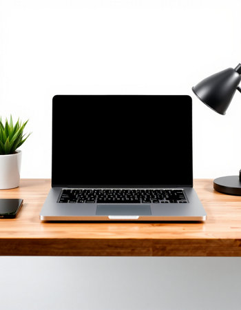 Laptop computer with blank screen on wooden table and white wall background