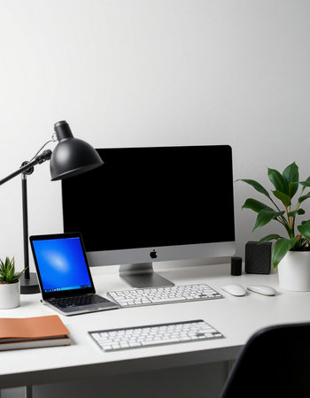 workplace with computer, lamp and other items on white wall background